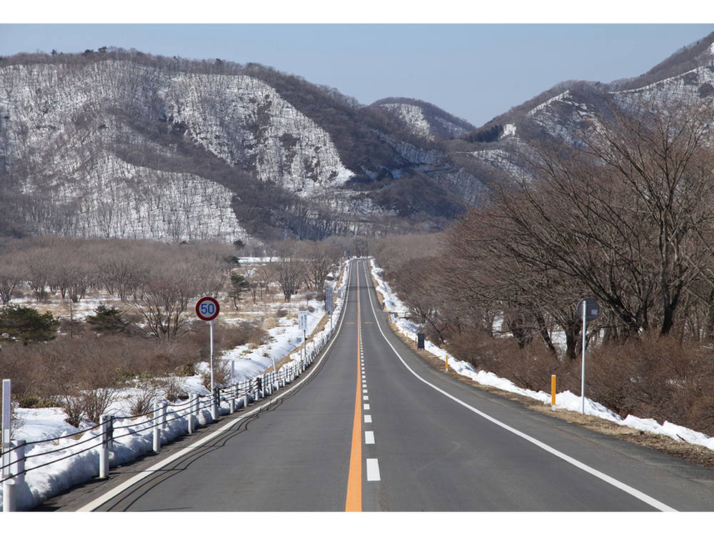 山の上とは思えないまっすぐに延びる道